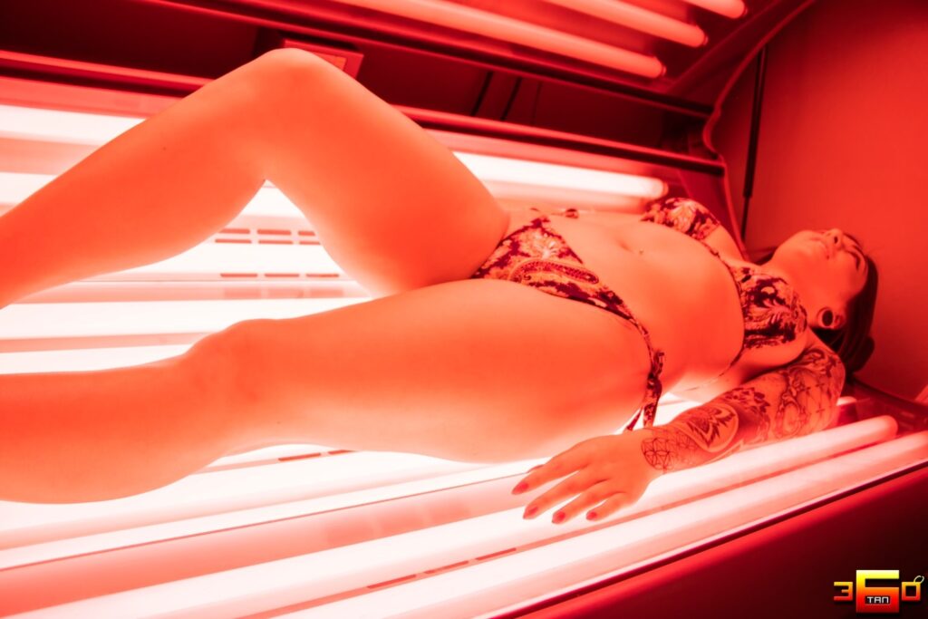 woman using a red light therapy bed at 360 Tan in Bakersfield